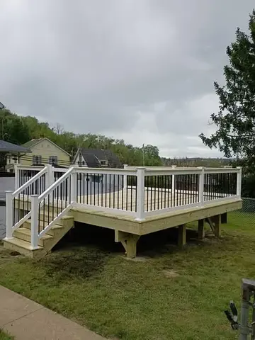 Wooden deck with white railings by KMA Carpentry
