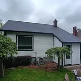 White-sided house with partial deck by KMA Carpentry